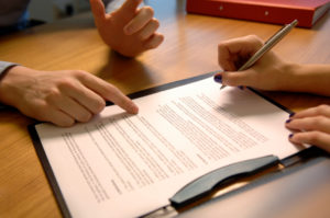 document being signed and reviewed by two people