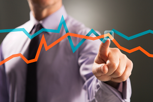 man's finger pointing to overlapping graphs analytics