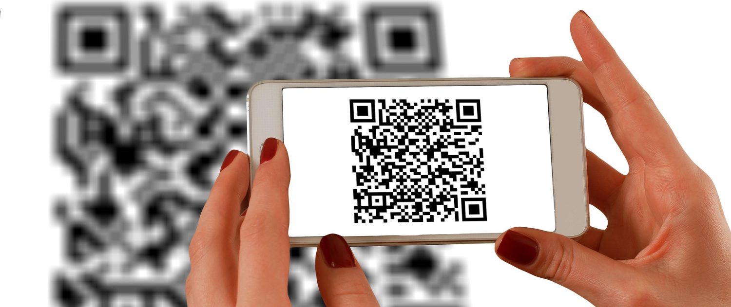 a woman is holding a cell phone with a qr code on it
