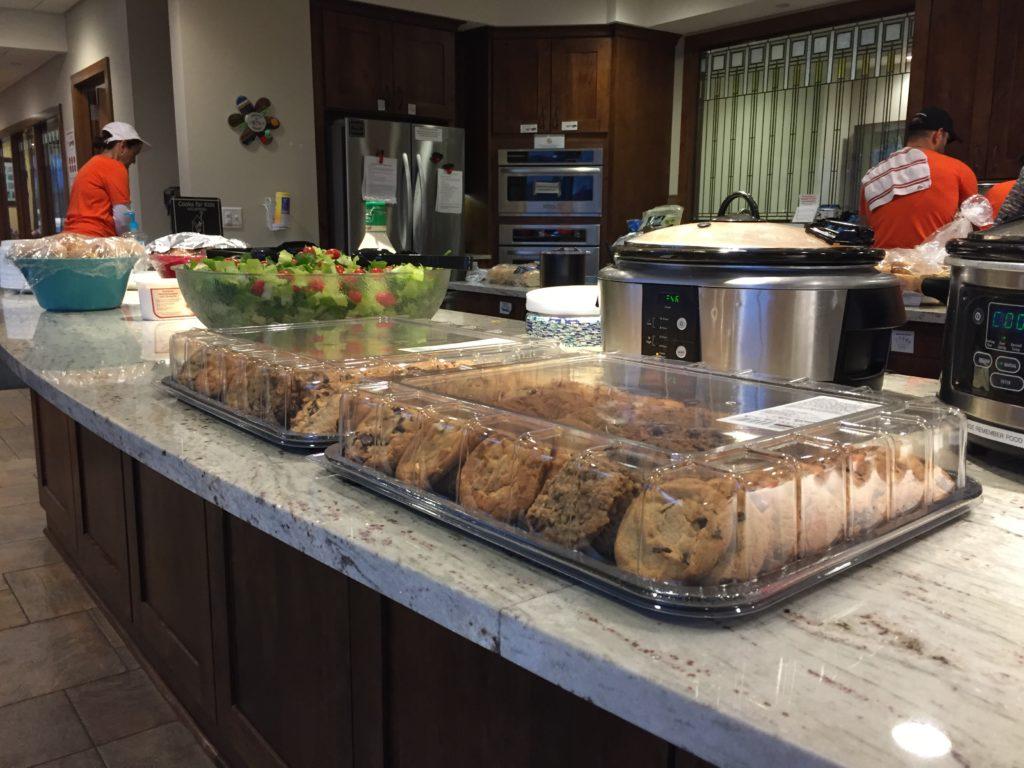 a counter with a crock pot and a tray of cookies