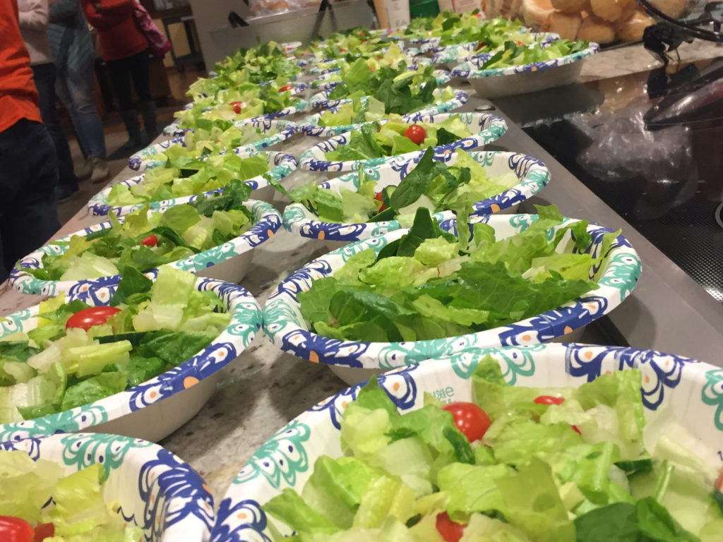 a row of paper bowls filled with lettuce and tomatoes with the word home on them