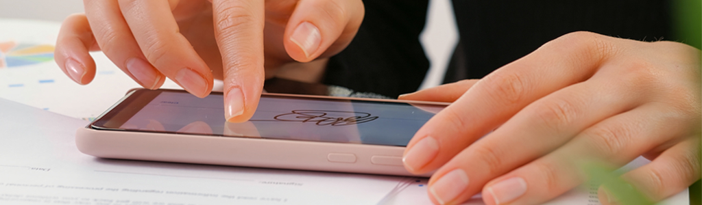 two hands, one hand uses one finger to sign a digital signature on a mobile phone