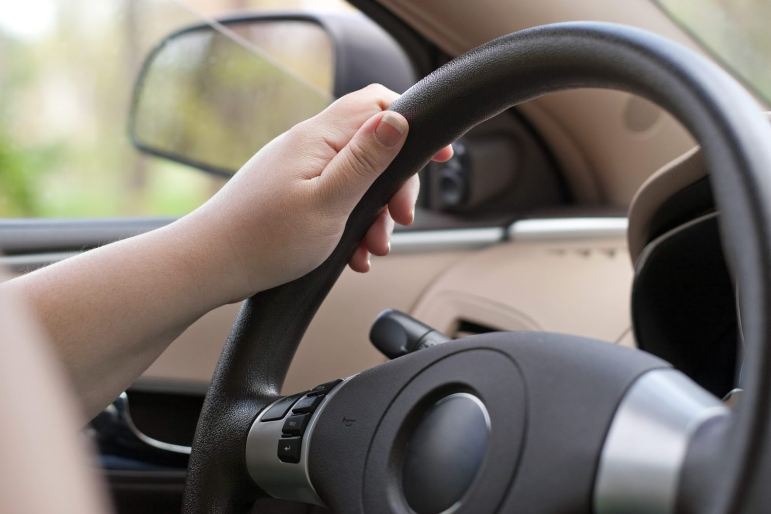 a person 's hand is on the steering wheel of a car