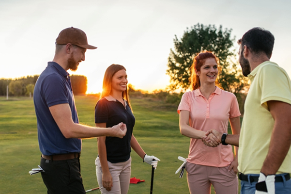 a group of people shaking hands on a golf course
