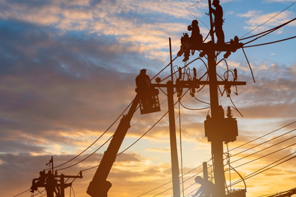 a group of men are working on power lines at sunset