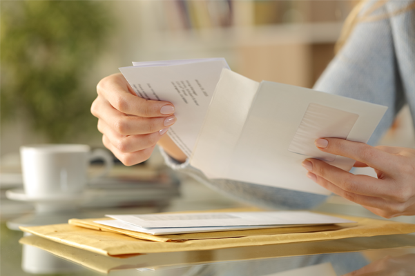 a woman is holding an envelope with a letter in it