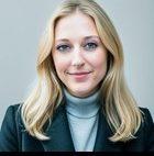 a woman with blonde hair is wearing a black jacket and a turtleneck .