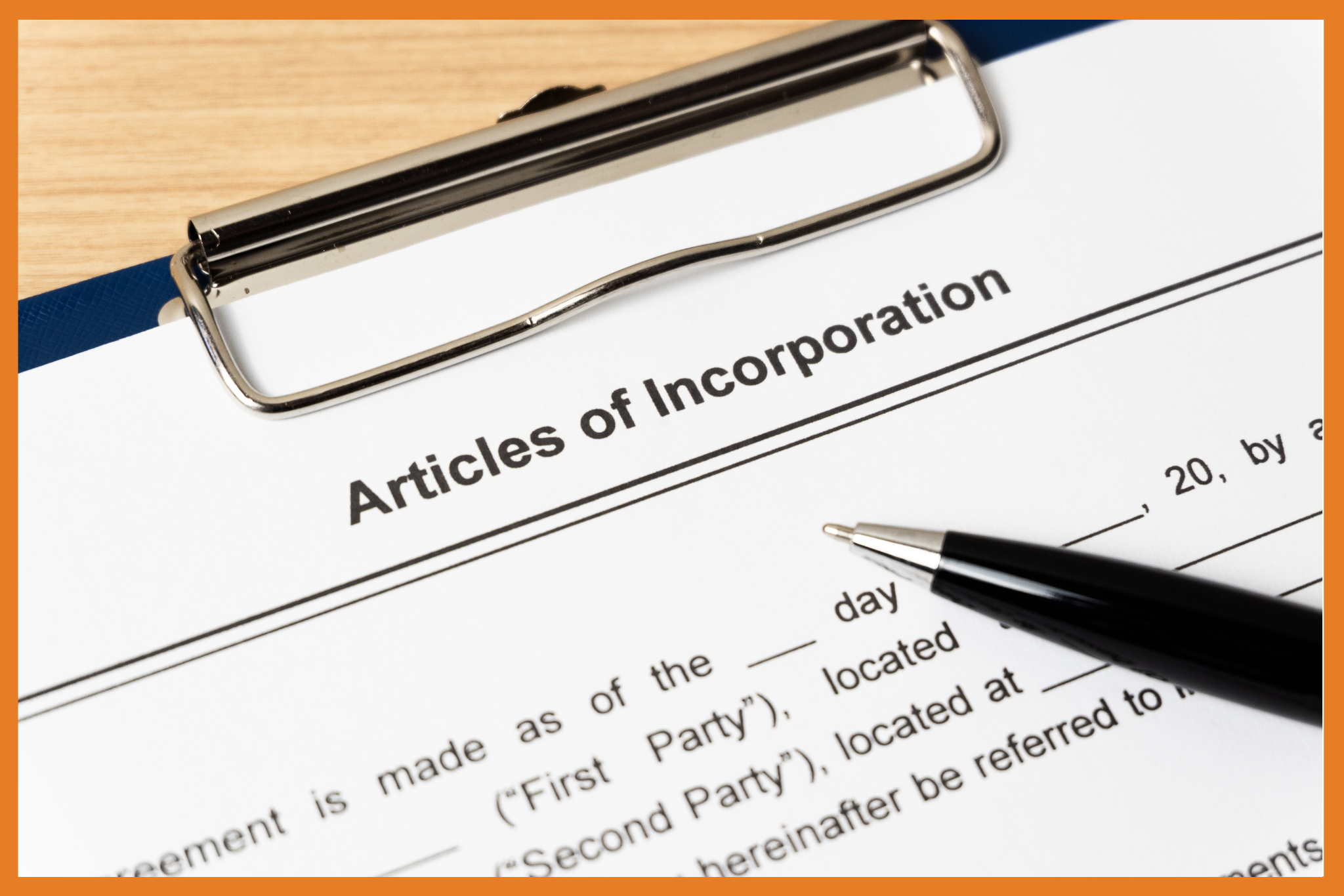 A close-up view of a clipboard holding a document titled Articles of Incorporation, with a black pen resting on the paper. The image is bordered by an orange frame.